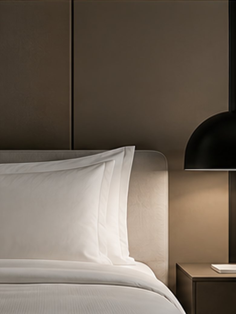 Hotelbett mit Leuchte und Nachttisch